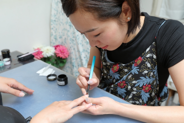 ネイルアートを施術する女性